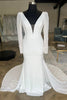 Vestido de noiva comprido, em branco, corte sereia, com decote em V profundo, costas abertas, mangas compridas e cauda