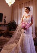 Vestido de novia de corte sirena con encaje de lentejuelas y cuello alto sin mangas