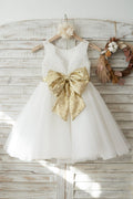 Vestido de niña de las flores de boda con espalda en V de tul de encaje marfil, lazo de lentejuelas doradas